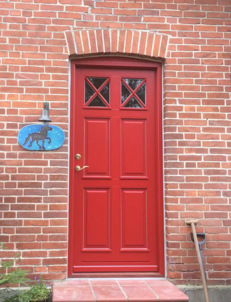 Ny indgangsdør i rød med fyldninger og glas i flot design