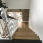 En 180 graders trappe med sort håndliste og klassiske udskæringer