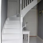 Hvidmalet kvartsvingstrappe med klassisk design og stødtrin