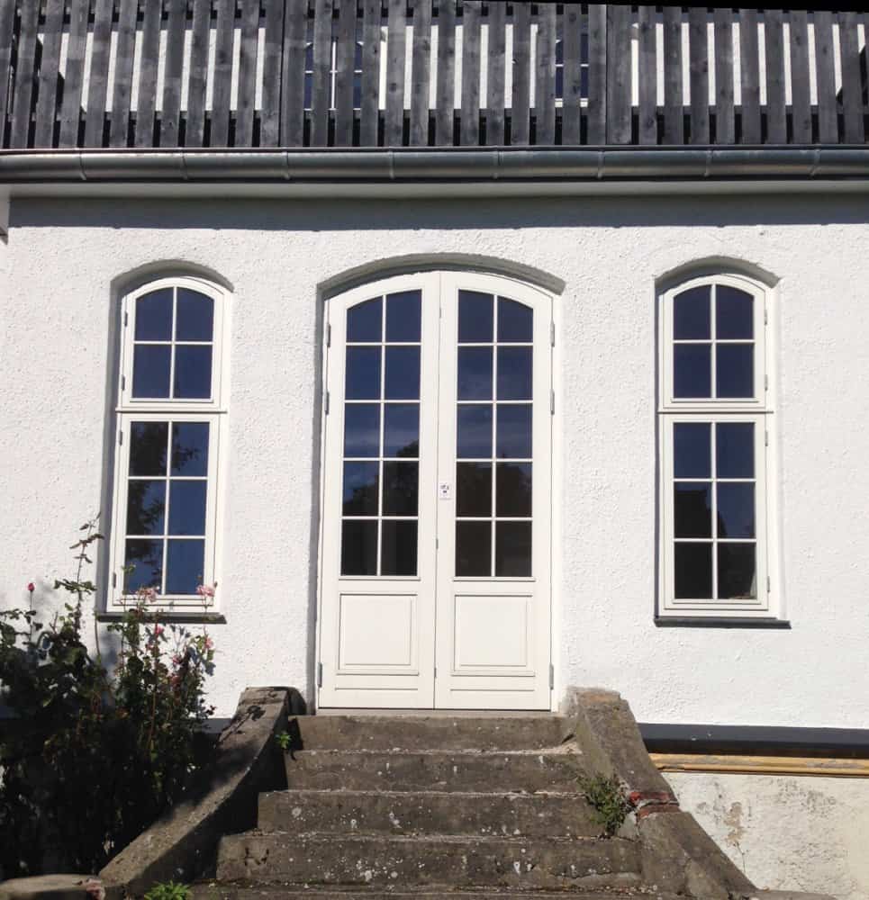 Hvide vinduer og døre med buet overkarm