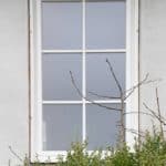pvc vindue med sprosser og råglas som er hvidt og åbner indad