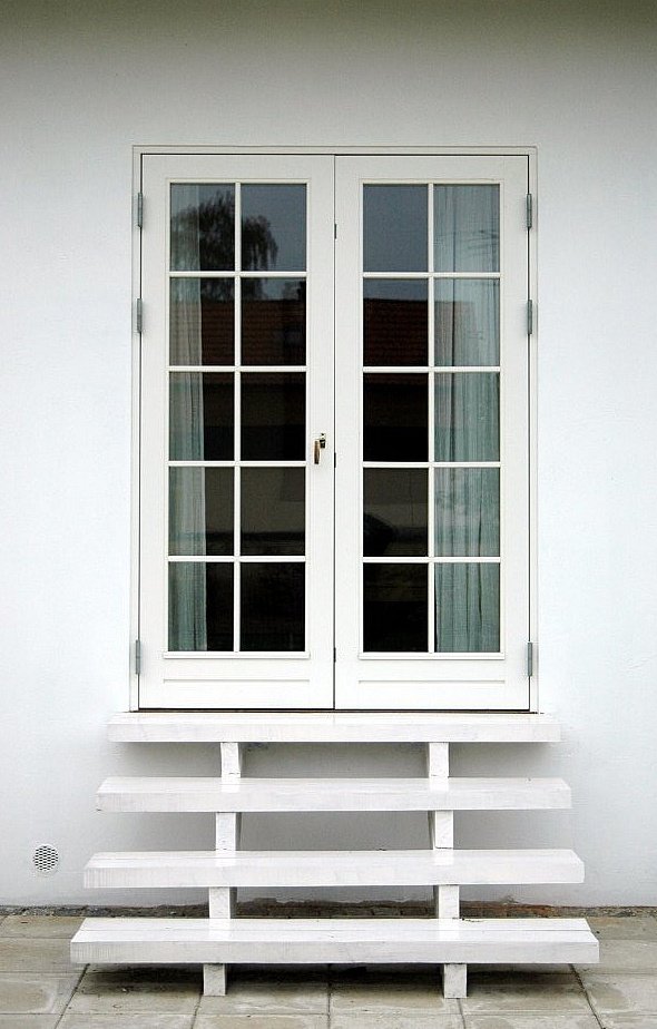 Småsprosset glasdør til terrassen med matchende hvid trappe